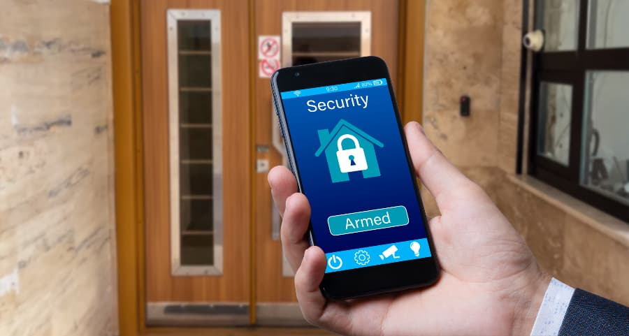 Man using mobile device to arm a security system